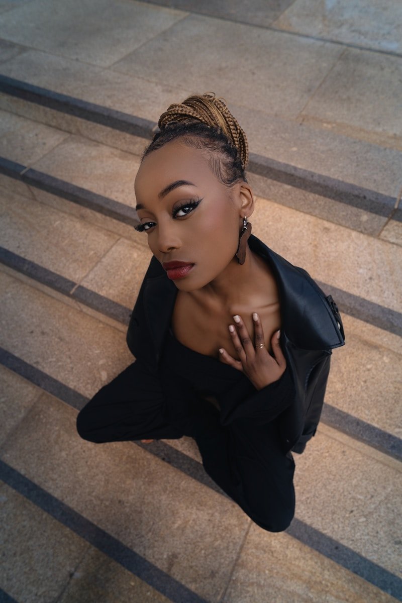 A woman is sitting on the steps posing for a picture