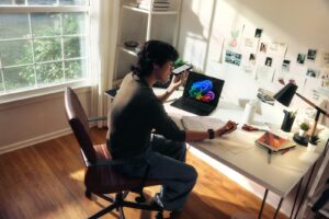 How to monetize a newsletter Person working at a desk with a laptop and books.