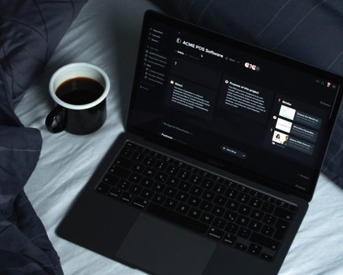 black laptop computer on white textile